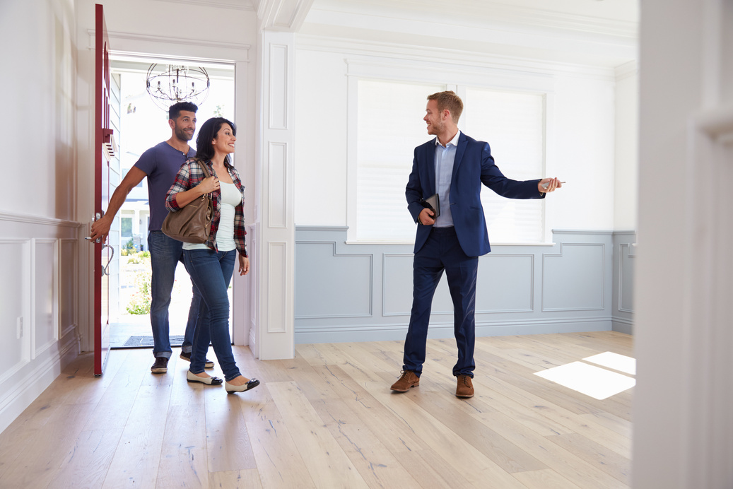 Realtor Showing Hispanic Couple around New Home